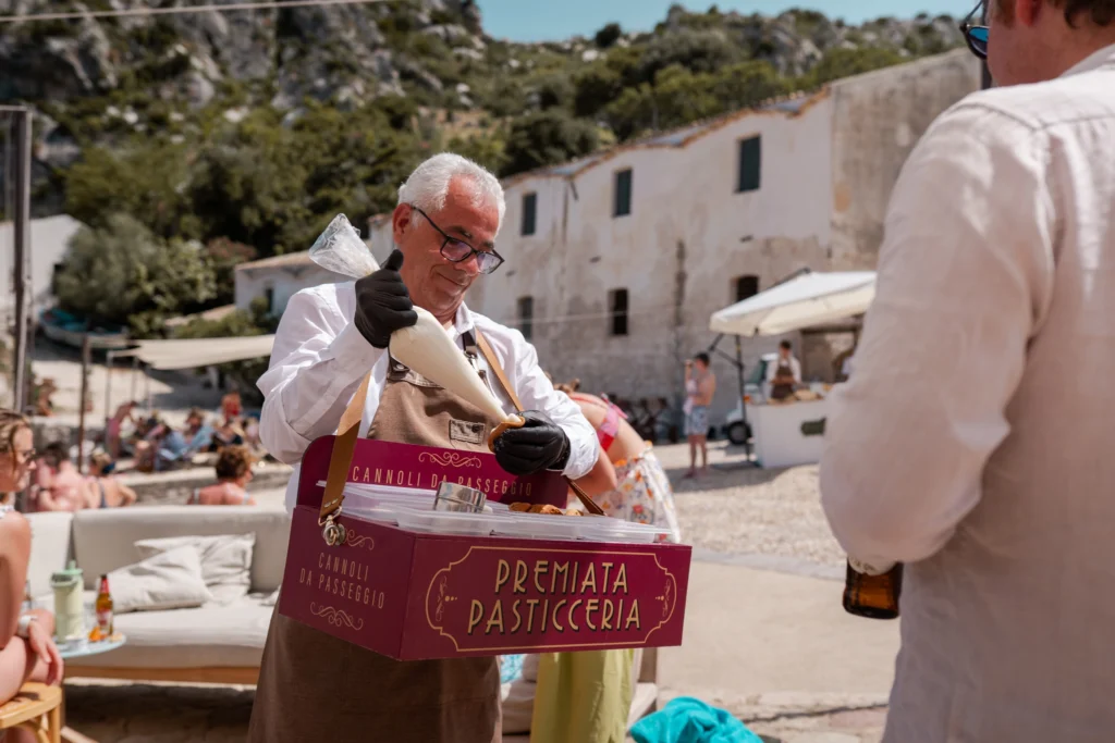 operatore che riempie live i cannoli siciliani con la ricotta
